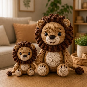 May include: Two handmade crochet lion plush toys in different sizes. Both lions feature tan bodies, dark brown manes, cream-colored belly patches, and dark brown tail tufts. They have black safety eyes and embroidered noses and mouths.