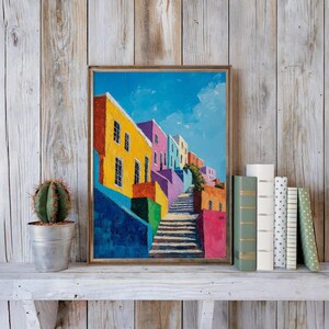 Peut inclure: Une peinture à l'huile encadrée représentant une scène de rue méditerranéenne vibrante avec des bâtiments colorés jaunes, roses et bleus bordant un escalier en pierre menant vers le haut sous un ciel bleu vif avec des nuages blancs.