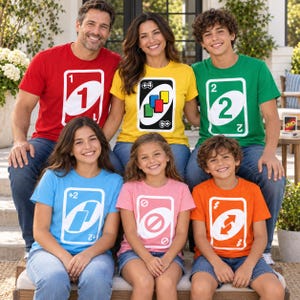 May include: A group of six people wearing colorful t-shirts, each featuring a large graphic of a different Uno playing card. The shirts are red, yellow, green, light blue, pink, and orange, displaying card numbers and symbols like +4, +2, skip, and reverse.