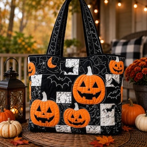 May include: A quilted tote bag featuring a black and white marble-patterned fabric interspersed with orange jack-o'-lanterns and black bat silhouettes. The bag has two sturdy fabric handles and a rectangular shape with detailed stitching throughout.