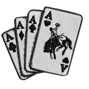 May include: A set of four embroidered patches shaped like playing cards, each featuring a black letter A and a suit symbol. The cards display the club, diamond, spade, and heart suits, with the heart card showing a bucking bronco rider graphic.