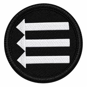May include: A circular embroidered patch featuring a black background with three horizontal white arrows pointing to the left. The arrows are stacked vertically and aligned on the left side, all enclosed within a thick black stitched border.