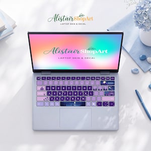 Peut inclure: Un ordinateur portable violet clair doté d'un autocollant de clavier personnalisé avec des touches violet foncé et des lettres blanches. Les touches présentent diverses illustrations nocturnes, dont un lac au clair de lune sur la barre d'espace.