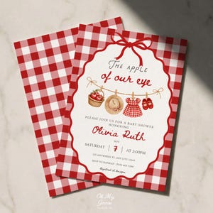 Puede incluir: Una tarjeta de invitación para baby shower con un patrón de cuadros vichy rojo y blanco. El centro tiene un marco blanco festoneado con un lazo rojo, el texto The apple of our eye e ilustraciones de una cesta de manzanas, un sombrero, un vestido y zapatos.