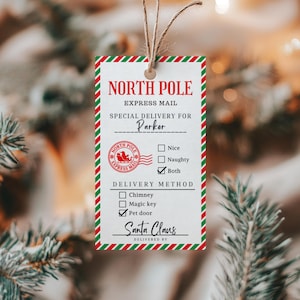 Puede incluir: Una etiqueta de regalo rectangular blanca con un borde de rayas diagonales rojas y verdes, que presenta el texto North Pole Express Mail, Special Delivery for Parker, y casillas de verificación para Nice, Naughty o Both, con la firma de Santa Claus.