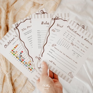 Puede incluir: Un juego de cuatro tarjetas de papel blanco para baby shower con texto marrón y bordes a rayas. Las tarjetas incluyen títulos como Children's, The Price, Baby Scramble y Predictions & Advice, con líneas para escribir, listas de emojis.