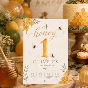 Puede incluir: Una tarjeta de invitación de cumpleaños rectangular blanca con ilustraciones en acuarela de panales, abejas y hojas verdes. El texto dice oh honey, 1, Oliver's First Birthday, November 7th 2026, 2:00 PM, 123 Anywhere St, Any City 12345, y RSVP to Hannah at 123-456-7890.