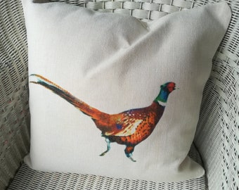 May include: A white throw pillow with a colorful pheasant illustration. The pheasant is facing right and has a long tail.