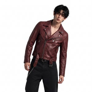 May include: A deep burgundy leather motorcycle jacket with a notched collar, silver-tone metal zips, and a buckled waist belt, paired with loose-fitting black denim jeans featuring a silver chain accessory and black leather boots.