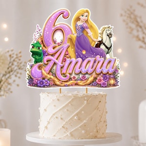 Peut inclure: Une décoration de gâteau avec un grand chiffre 6 violet et le prénom Amara en écriture cursive violette. Le design inclut un personnage blond en robe violette, un caméléon vert, un cheval blanc et des fleurs, posé sur un gâteau blanc givré.