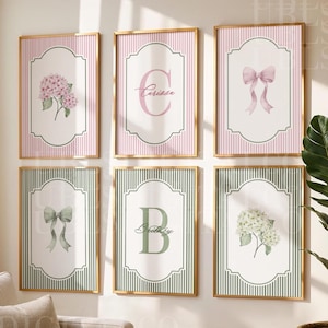 May include: A set of six rectangular wall art prints in gold frames. The top row features pink striped backgrounds with a hydrangea, the letter C with the name Carissa, and a pink bow. The bottom row has green striped backgrounds with a green bow, the letter B with the name Britney, and white hydrangeas.