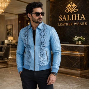 May include: A light blue leather jacket featuring a dark grey snakeskin pattern, a full-length front zipper, a classic collar, and ribbed cuffs. The jacket is worn over a black shirt and paired with black trousers, creating a structured look.