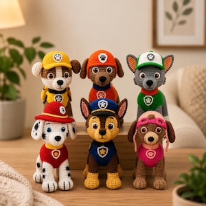 Peut inclure: Un ensemble de six figurines en crochet représentant des personnages de la Pat' Patrouille. Chaque personnage possède un code couleur distinct, incluant le jaune, l'orange, le vert, le rouge, le bleu et le rose, avec des chapeaux et des écussons.