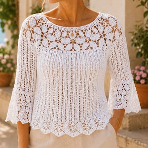 May include: A white crochet top featuring a round neckline with a floral motif pattern, three-quarter length bell sleeves, and a scalloped hem. The bodice is constructed with vertical openwork stripes, while the yoke and cuffs display intricate floral lace detailing.