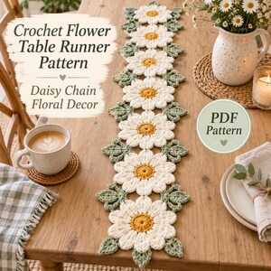 Puede incluir: Un camino de mesa de ganchillo con un patrón repetitivo de margaritas de pétalos blancos y centros amarillos, intercalado con hojas verdes tejidas. El texto dice Crochet Flower Table Runner Pattern Daisy Chain Floral Decor PDF Pattern.