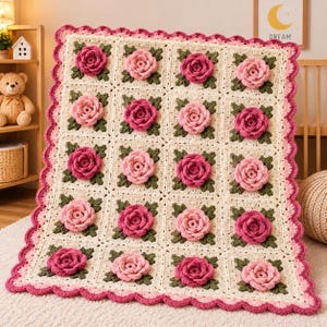 May include: A square crochet blanket featuring a grid of cream-colored squares, each adorned with a three-dimensional rose in varying shades of pink and dark green leaves. The blanket is finished with a scalloped border in pink and cream.