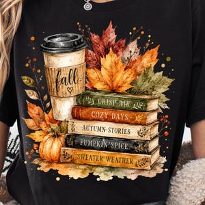 Op de afbeelding: Een zwart t-shirt met een afbeelding van een koffiebeker met het woord fall en een hartje, een stapel van vijf boeken met de titels Crisp Air, Cozy Days, Autumn Stories, Pumpkin Spice en Sweater Weather, omringd door oranje en rode herfstbladeren.