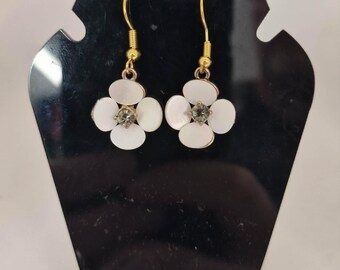 Pendientes de aro dorados de plata 925 con diseño de flor blanca.
