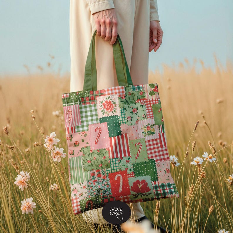 May include: A fabric tote bag featuring a patchwork design of green, red, and pink squares with patterns of candy canes, flowers, gingham, and stripes. The bag has two olive green shoulder straps and a black circular logo tag reading INDIE WREN.