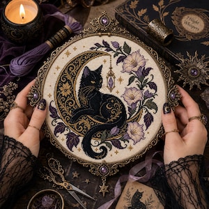 May include: A circular cross-stitch embroidery featuring a black cat resting on a golden crescent moon, surrounded by purple and white flowers. The piece is framed in an ornate, antique-style bronze metal hoop with purple gemstone accents.