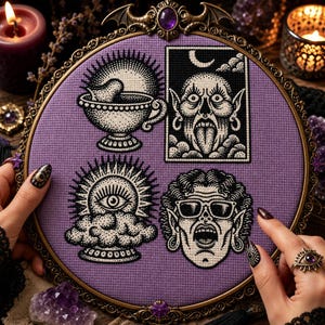 May include: A circular embroidery hoop with a purple fabric background featuring four black and white stitched designs: a teacup, a horned figure, a sun-like eye above clouds, and a face with glasses, all framed in an ornate bronze-coloured metal border.