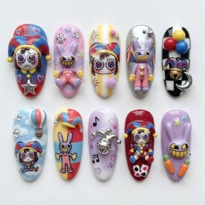 May include: A set of ten press-on nails featuring 3D charms and colorful designs including jester figures, rabbits, balloons, stars, hearts, musical notes, and playing card suits in a variety of bright colors like red, blue, yellow, and purple.