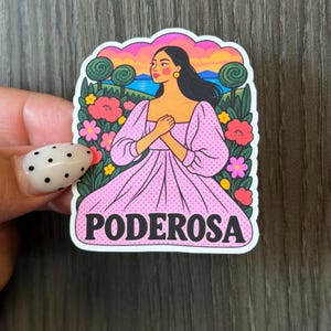 May include: A die-cut sticker featuring an illustration of a person with long dark hair wearing a pink polka-dot dress with puffed sleeves. The background shows a landscape with flowers, trees, and a sunset. The word PODEROSA is printed in black.