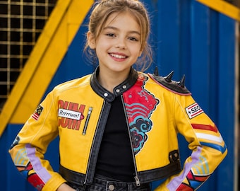 May include: A bright yellow cropped jacket with black trim, featuring black shoulder spikes, a mandarin collar, and colorful graphic patches. The jacket includes text that reads Rrrrrum! and +SEO, with a black shirt and dark gray jeans underneath.