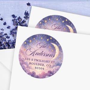 May include: Two circular address labels featuring a watercolor night sky with a crescent moon, hanging stars, and purple clouds. The text reads The Andersons, 109 S Twilight Ct. Boulder, CO 80304 in a dark purple script and serif font.