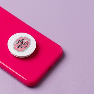May include: A white phone grip with a pink brain design and the text "I have absolutely no idea" on a pink phone case.
