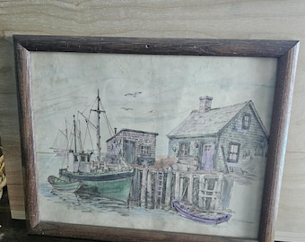Lámina enmarcada firmada por Jay Killian, estilo vintage, con la imagen de una casa con barcos en el puerto.