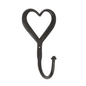 May include: A black metal wall hook featuring a heart-shaped top section and a curved lower hook. The surface has a textured, dark finish with a single small circular hole located at the junction where the heart meets the hook stem.