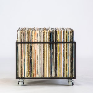 Front view of a minimalist black metal vinyl record storage cart filled with LPs, showing colorful record spines and mounted on four rubberized wheels for easy mobility.