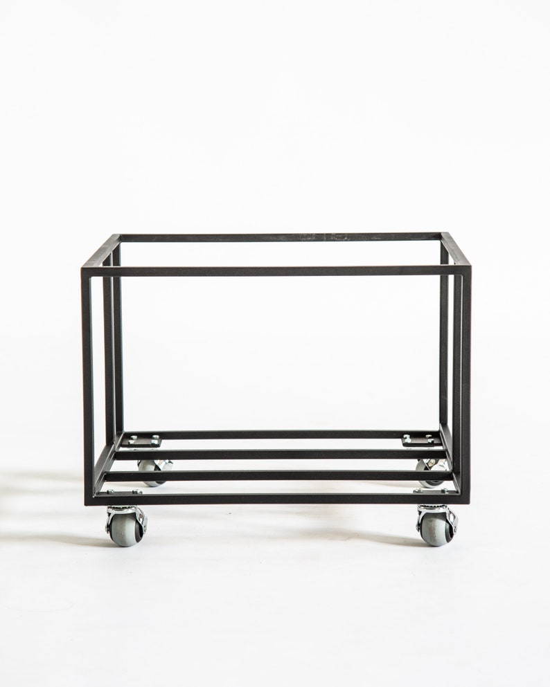 Minimalist black metal vinyl record storage cart with a clean rectangular frame and four rotating caster wheels, photographed against a white background.