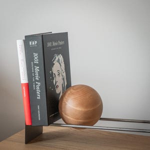 Minimalist rack with books and supporting wooden ball.