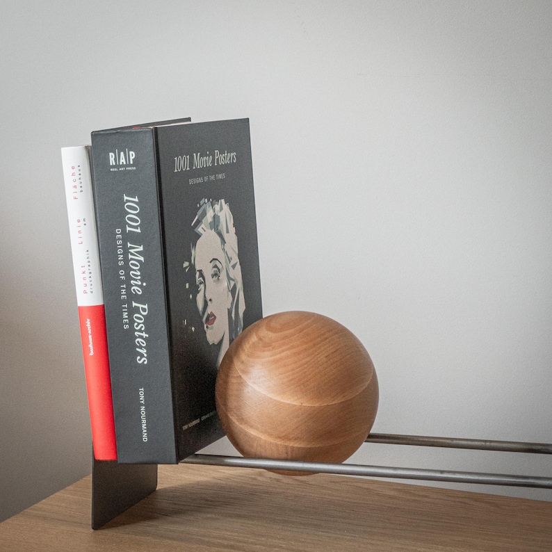 Minimalist rack with books and supporting wooden ball.