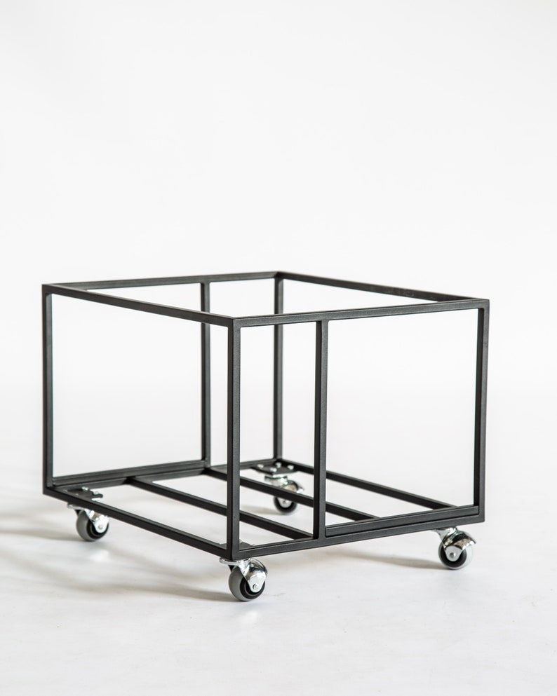 Angled view of an empty black metal vinyl record cart with a minimalist open-frame design, featuring four caster wheels for easy movement and industrial-style construction.