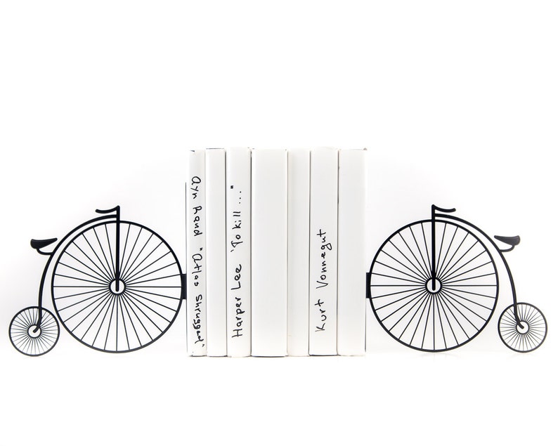 Black metal bookends Penny or Farthing Bike. The metal bike is on each side of the bookends. It is attached to the metal base with the side and the bottom, which holds the books vertically. The books press onto the bottom of the bookend.