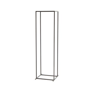 Angle view of a tall minimalist black metal log rack frame with four legs, showing modern Scandinavian firewood holder design.