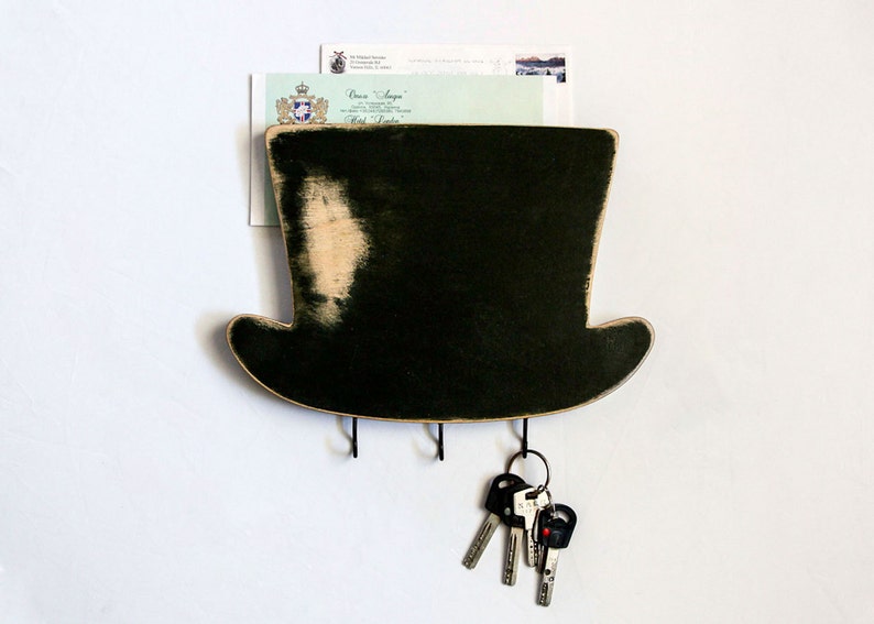 Whimsical black wooden mail and keys wall organizer for your entryway in the shape of a high hat. The organizer is fitted to the wall, has a pocket for mail, and has three hooks underneath for your keys. Made by us in our workshop in Ukraine.