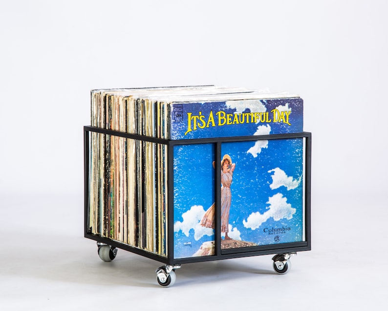 Black metal vinyl record storage cart on rubber wheels, filled with LPs including the album “It’s a Beautiful Day” facing forward — minimalist industrial design for storing and displaying vinyl records. hand-welded in Cherkasy, Ukraine. Not mass-produced.