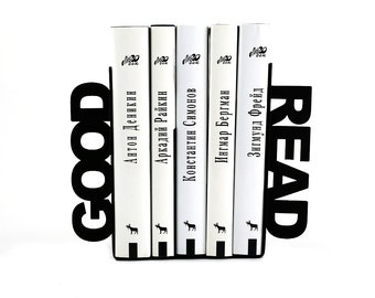 May include: Black metal bookends with the words "GOOD READ" in large letters. The bookends are holding up four white books with black text on the spines. The text on the spines reads "Антон Деникин", "Аркадий Райкин", "Константин Симонов", "Ингмар Бергман", and "Зигмунд Фрейд".
