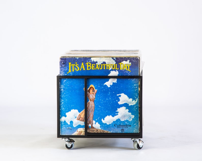 Front view of a black metal vinyl record cart on wheels, displaying the LP “It’s a Beautiful Day” in the front slot — minimalist industrial design for stylish vinyl record storage and display.