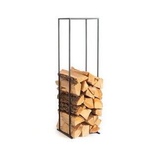 Tall minimalist black metal log rack filled with stacked firewood, showcasing modern Scandinavian indoor firewood storage design. Handmade in Cherkasy, Ukraine by Atelier Article. Not mass-produced.