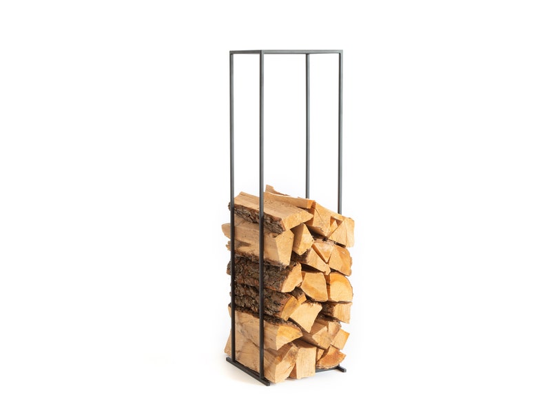 Tall minimalist black metal log rack filled with stacked firewood, showcasing modern Scandinavian indoor firewood storage design. Handmade in Cherkasy, Ukraine by Atelier Article. Not mass-produced.