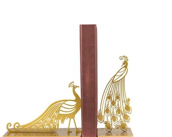 May include: A pair of gold metal bookends shaped like peacocks. The bookends are holding up a burgundy book.