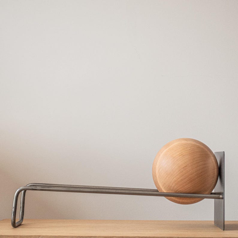 Minimalist wooden rack for books or vinyl records with supporting wooden ball.