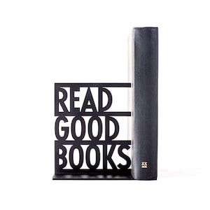 以下が含まれることがあります： 黒い金属製のブックエンドで、「READ GOOD BOOKS」という文字が太字の白い文字で書かれています。黒い本がブックエンドで支えられています。