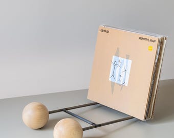 Moderne minimalistische vinylplatenstandaard: sculpturale schuine boekenplank met houten bollen