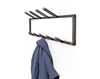 May include: A black metal coat rack with six hooks and copper accents. A blue jacket is hanging on one of the hooks.